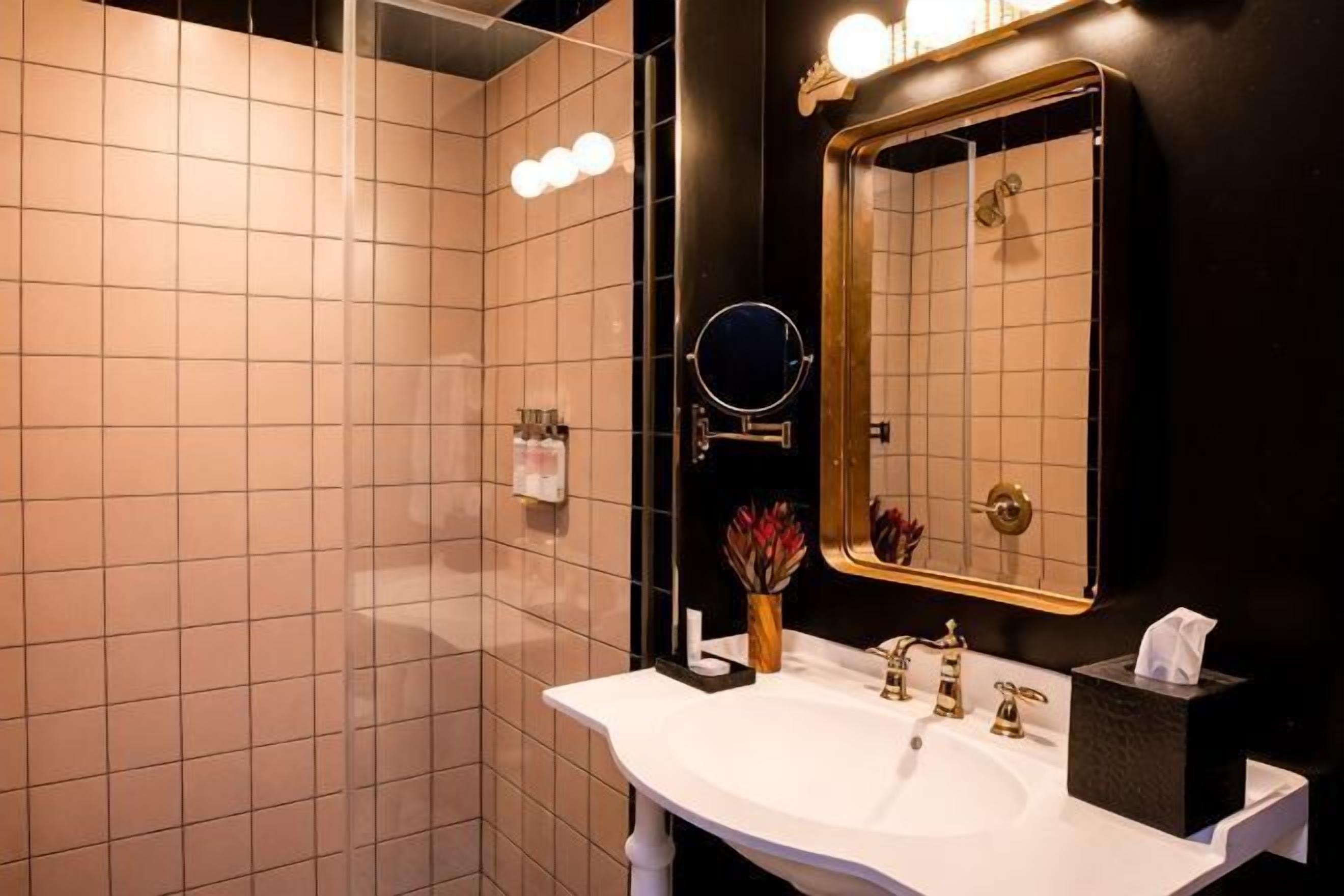 Une salle de bain avec un lavabo blanc, un miroir et un porte-serviettes.