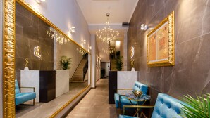 Un vestíbulo moderno con mostrador de recepción, zona de estar y escalera.