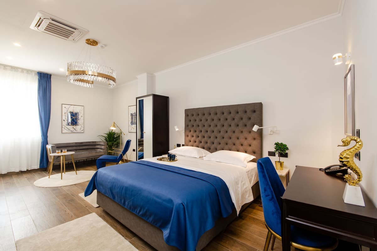 Una habitación de hotel moderna con una cama grande, un escritorio y una silla.