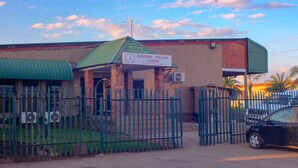 A building with a sign reading "Golden Pillow Lodge" and a gated entrance. - Golden Pillow Lodge Monze (Monze)