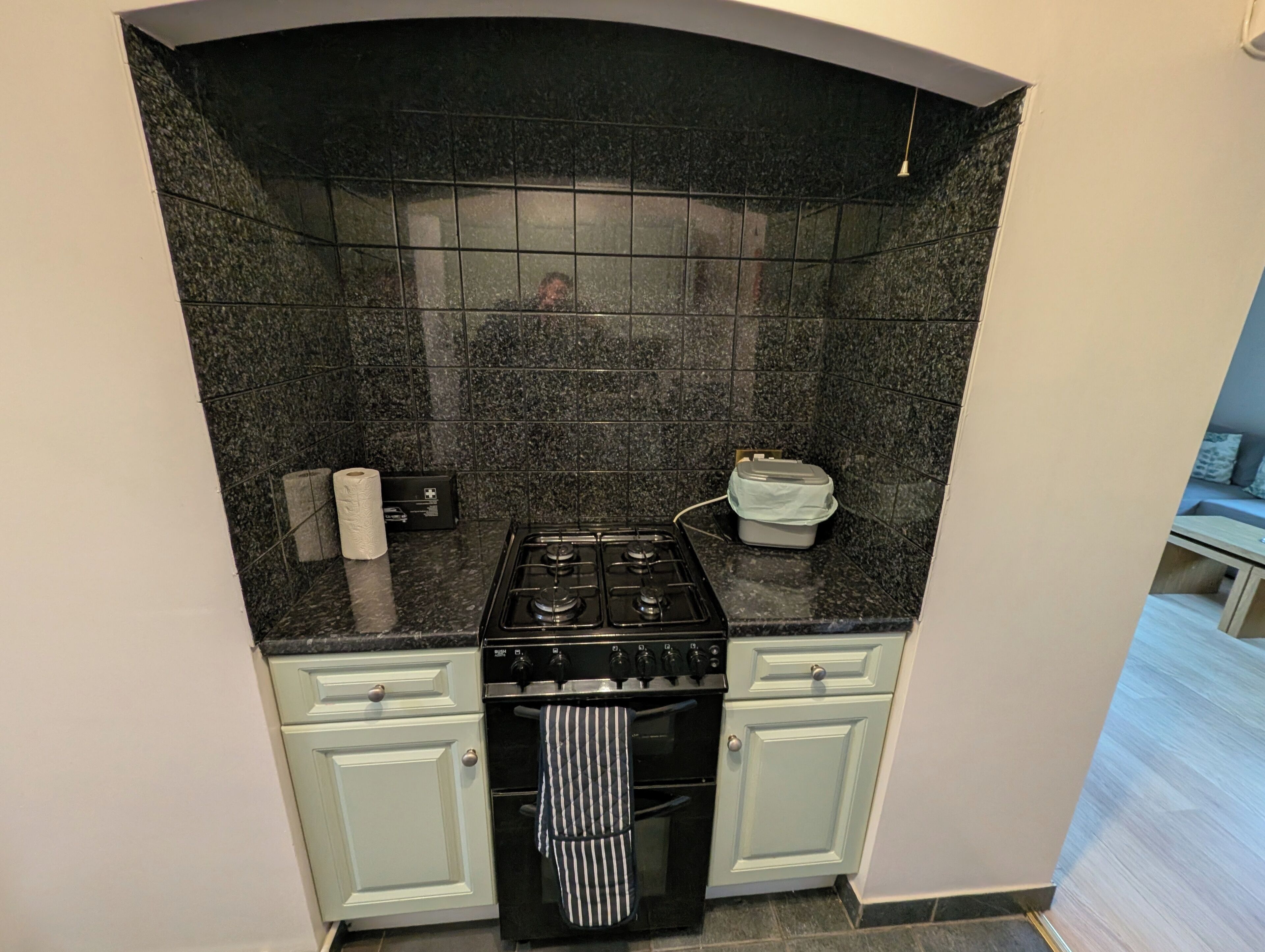 Uma cozinha compacta com fogão a gás, forno e uma bancada pequena.