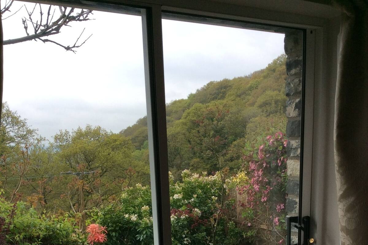 Une porte-fenêtre coulissante donnant sur un patio extérieur équipé d’une table et de deux chaises.