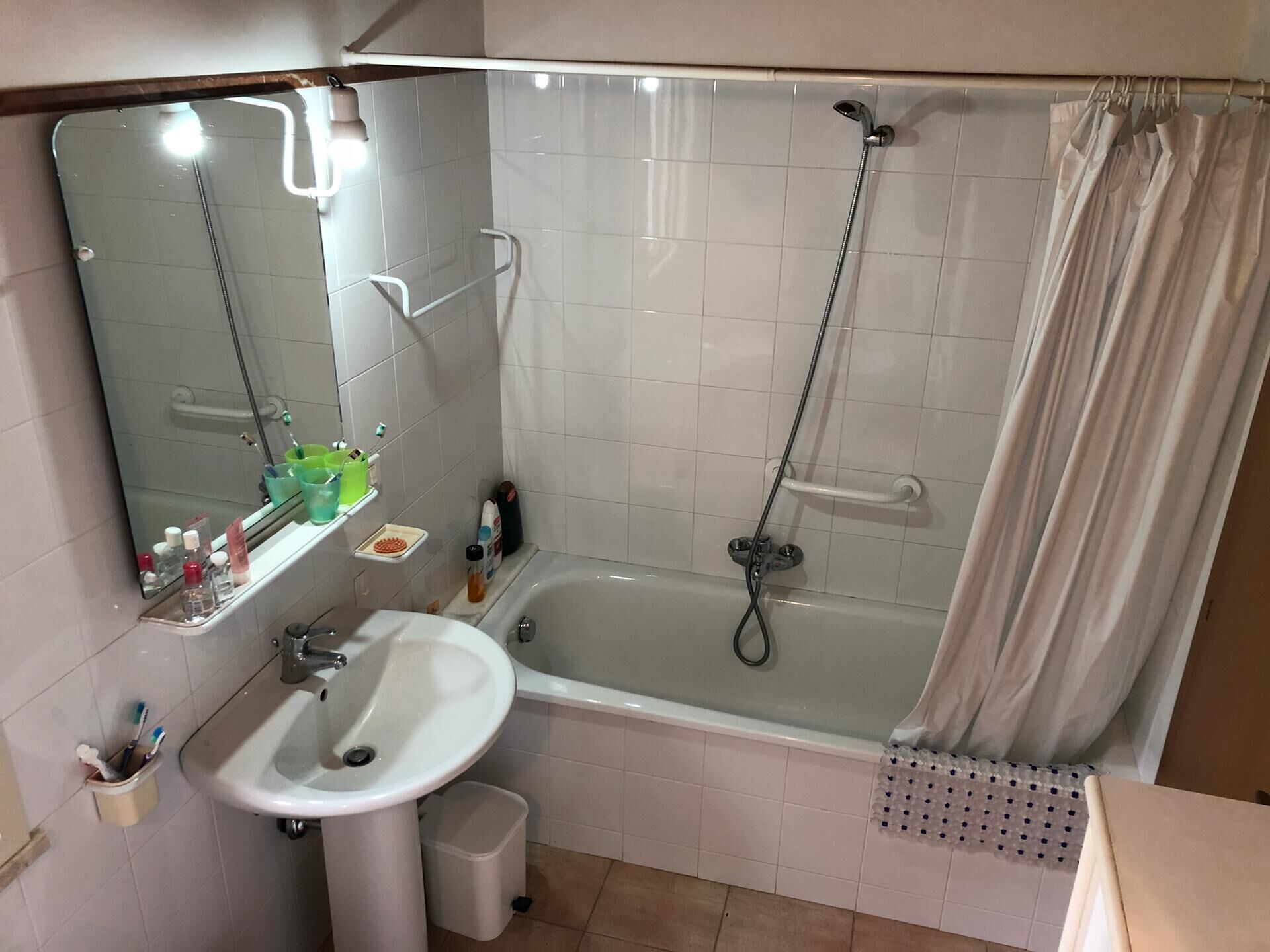 A bathroom with a bathtub, a sink, a mirror, and a shower.