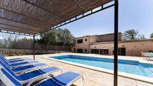 A poolside area with blue lounge chairs and a swimming pool. - Can Pere Xine, Mallorcan Charm near Cala Mondragó (santañy)