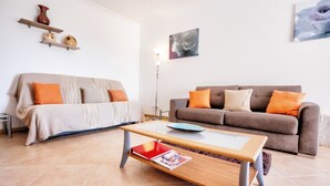 A living room with two sofas, a coffee table, and wall-mounted shelves with decorative items. - SAINT JAMES - APT SEA VIEW - 2 / 4PERS (Luz)