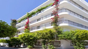 Un hotel de varios pisos con balcones decorados con plantas y flores.