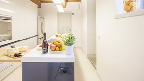 A modern kitchen with wooden beams, a built-in oven, a sink, and a fruit bowl on the counter. - Villa for 10 People with WiFi, Private Pool, Garden, A/C, near Lucca (Vorno)