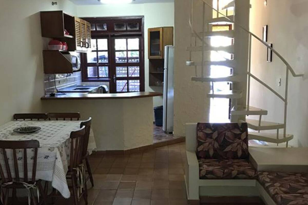 Une cuisine de taille réduite comprenant un coin repas, un escalier et une vue sur l’extérieur.