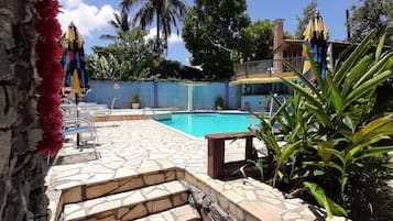 Una piscina al aire libre, sillones reclinables de piscina