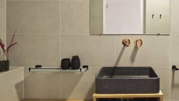 Un bagno moderno con un mobile bagno in legno, uno specchio grande e uno scaffale con articoli da toilette.