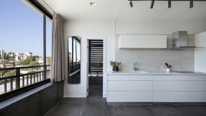 Cozinha moderna com uma janela grande, varanda e vista da cidade.