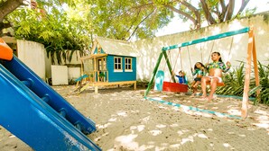Une aire de jeux avec un toboggan bleu et des balançoires.