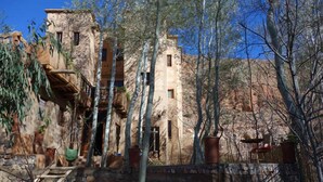 Un bâtiment rustique doté de nombreuses fenêtres et d’un mur de pierre à l’avant.