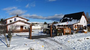 Lumipeitteinen sisäänkäynti rakennukseen, jonka yläpuolella on kyltti, jossa lukee Samy-Hue Bungalows.