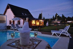 Ein Schwimmbecken mit Liegestühlen und einer Bar im Hintergrund.