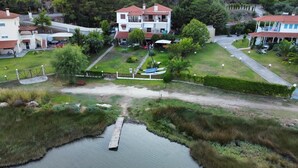 Zona residencial con un cuerpo de agua, un muelle de madera y casas con techos de tejas rojas.