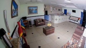 A spacious lobby with a reception desk, seating area, and a decorative staircase. - Pousada Ferreira (Aracaju)