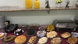 A buffet table with various food items and decorative elements. - Pousada Ferreira (Aracaju)