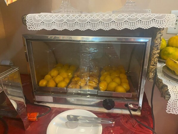 A buffet with a glass display case containing food items.