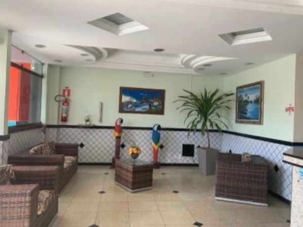 Un vestíbulo con mostrador de recepción, zona de estar y obras de arte en las paredes.