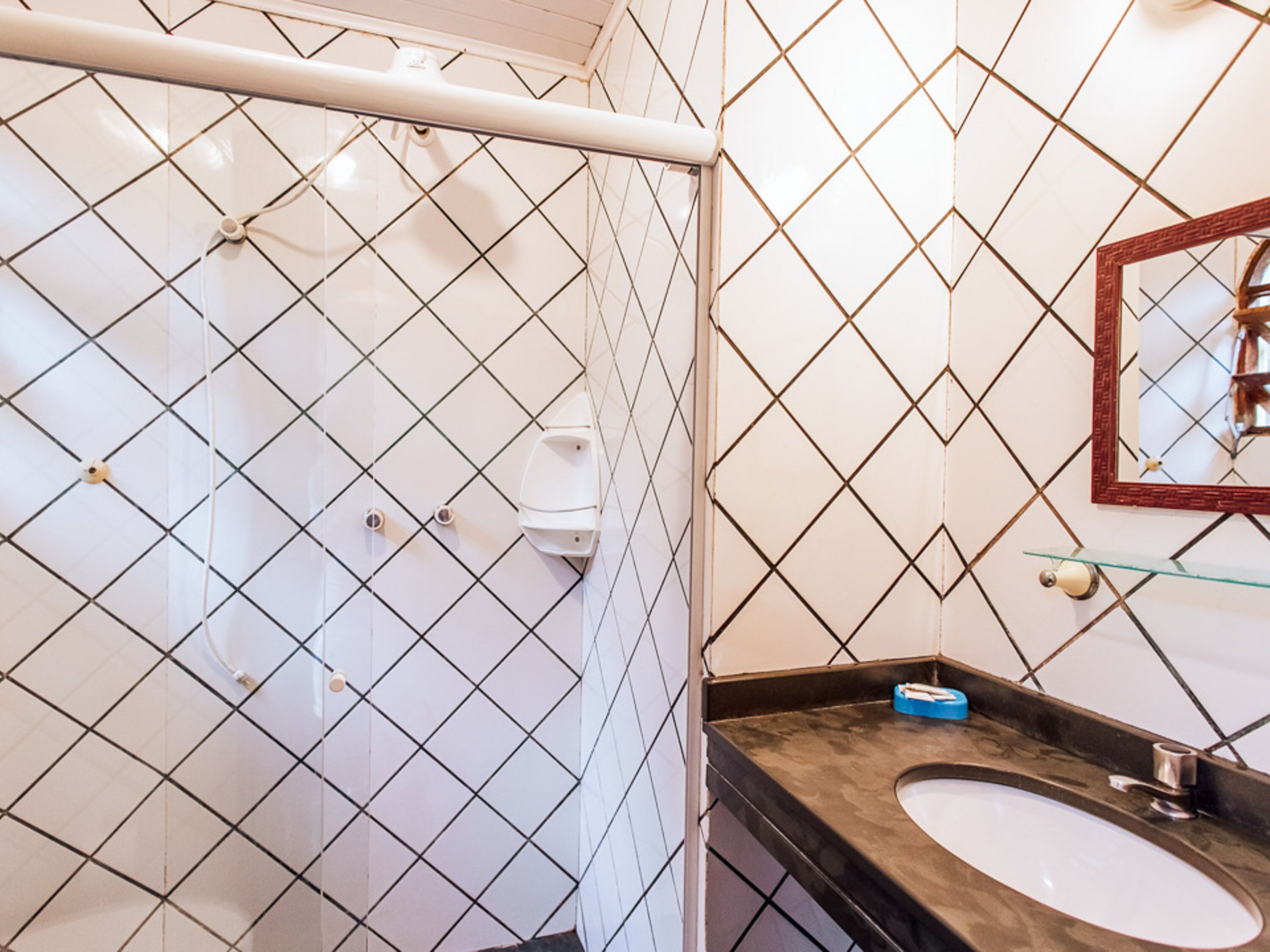 Un bagno con doccia, lavandino e specchio.