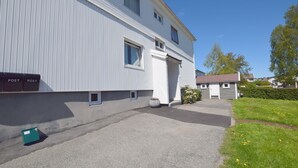 A two-story building with a flat roof, a small front porch, and a driveway leading to the entrance. - Solferie Apartment Odins Gate (Kristiansand)