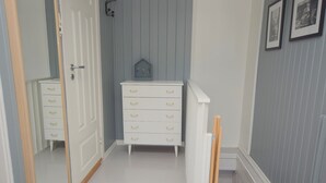 A hallway with a white dresser, a mirror, and a small decorative house. - Solferie Apartment Odins Gate (Kristiansand)