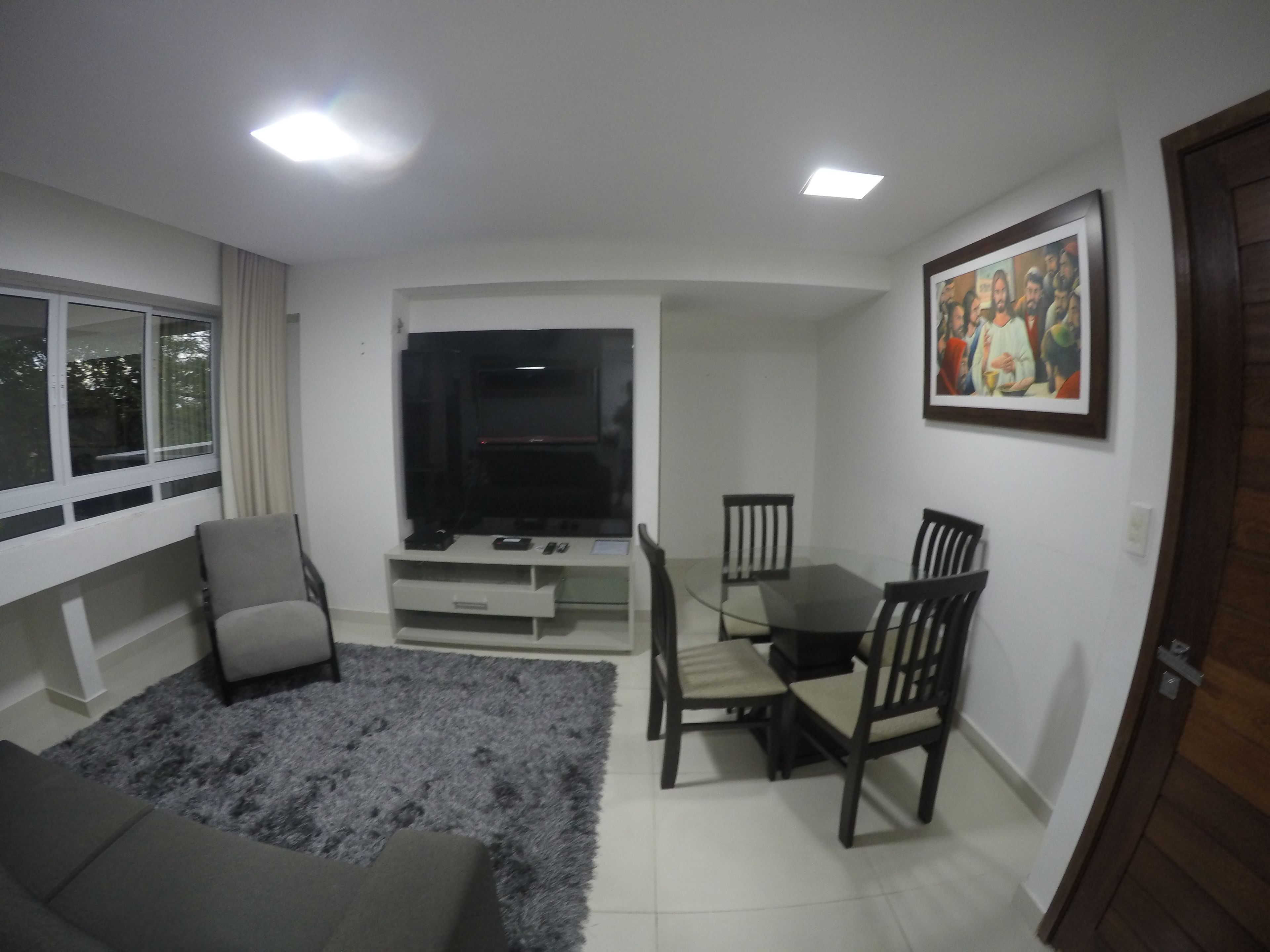 A living room with a sofa, TV, and dining table with chairs.