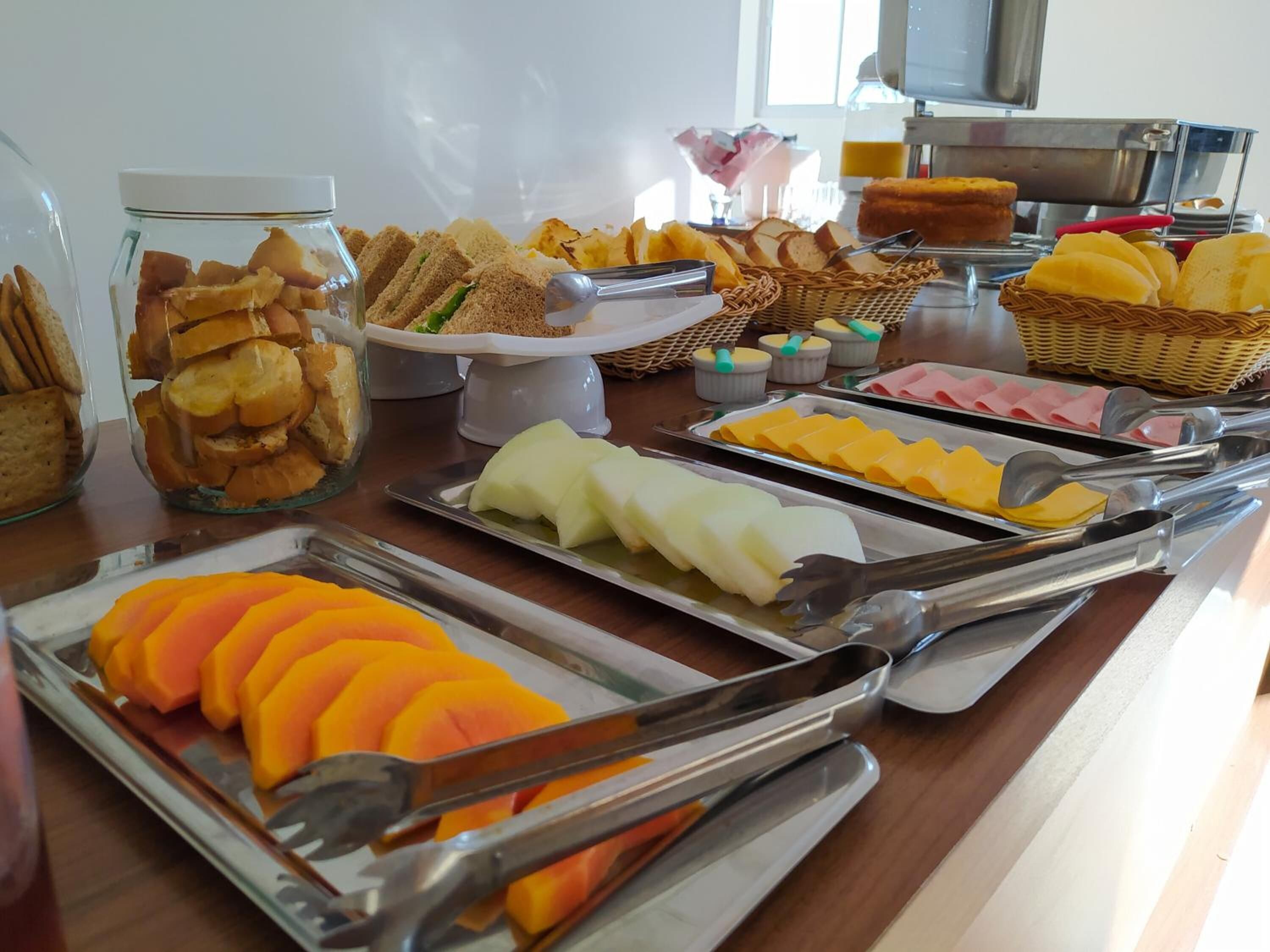 A buffet with various food items including bread, cheese, and fruits.