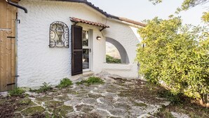 A rustic building with a white exterior, a wooden door, a window with decorative ironwork, and a stone-paved entrance. - N111 - Numana, single villa with garden and sea view (Numana)