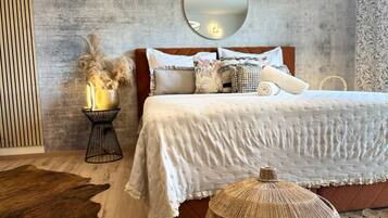 A bedroom with a bed, a round mirror, and a rustic decor.