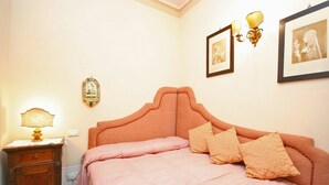 A bedroom with a bed, a nightstand, a lamp, and wall-mounted lights. - Santo Agostino Belvedere - Apartment in Cortona (Cortona)