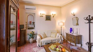 A cozy living room with a sofa, a wooden cabinet, a mirror, and a fruit bowl on a table. - Santo Agostino Belvedere - Apartment in Cortona (Cortona)