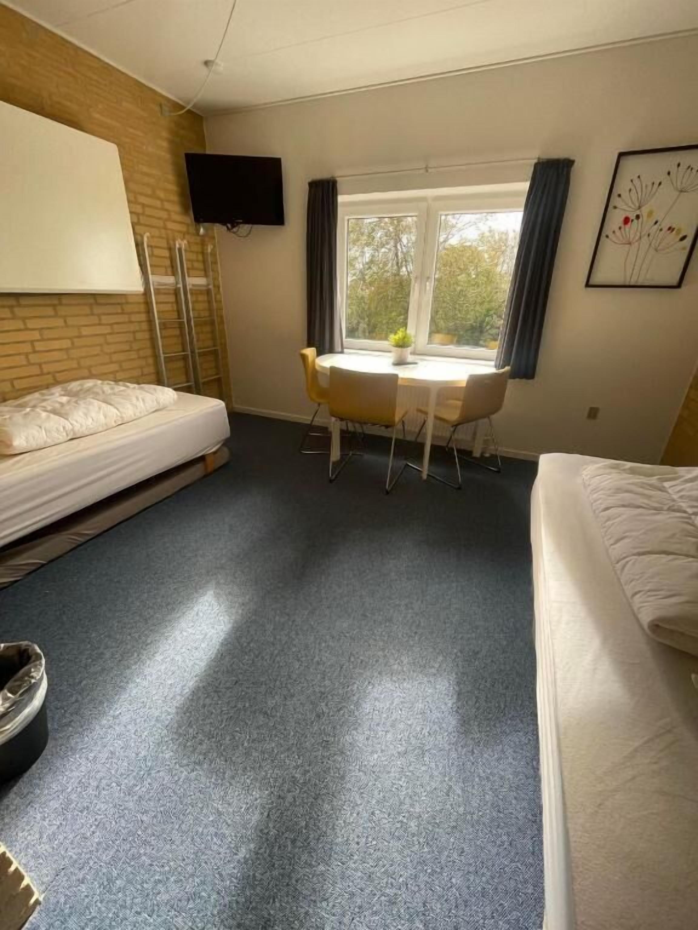 Una habitación con una cama, un escritorio y una silla.