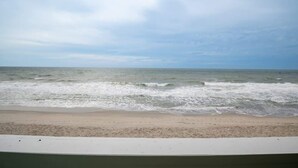 A beach with waves and a cloudy sky.