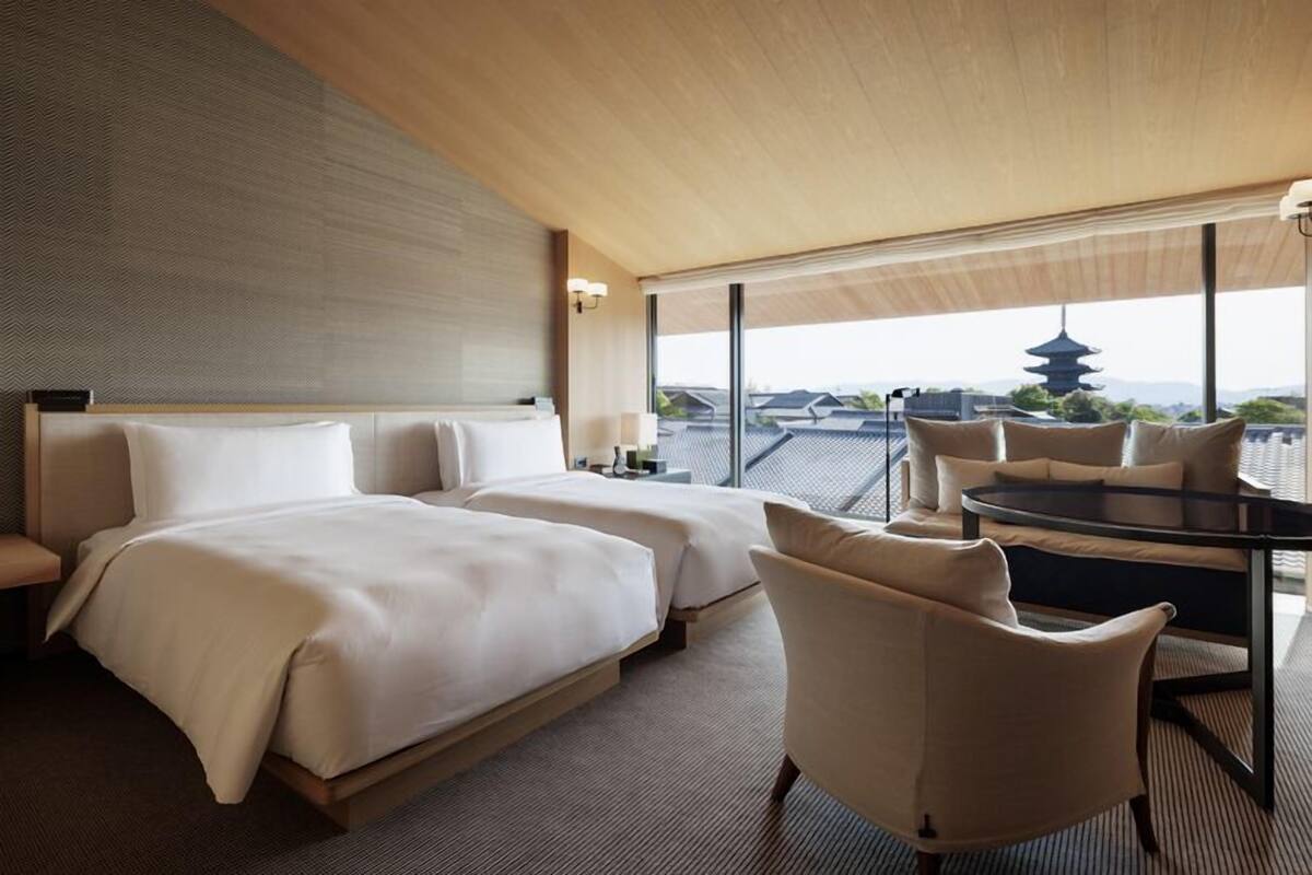 Ein Hotelzimmer mit zwei Betten, einem Esstisch und Blick auf eine Pagode.