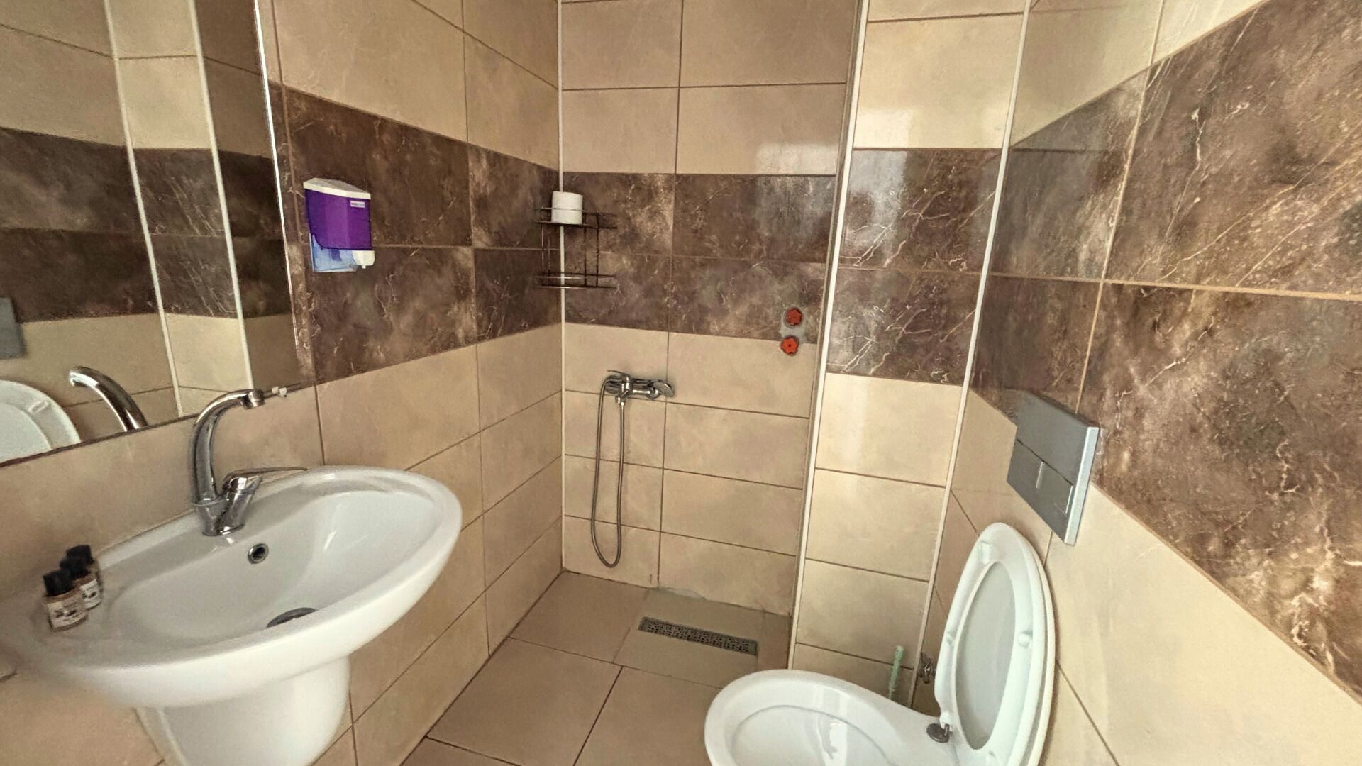 A bathroom with a sink, toilet, and shower.