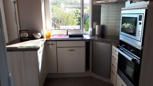 Una cocina con microondas, horno y lavabo integrados.