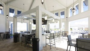 A spacious outdoor area with a bar, seating, and a TV screen. - Storey Lake 4820 (Kissimmee)