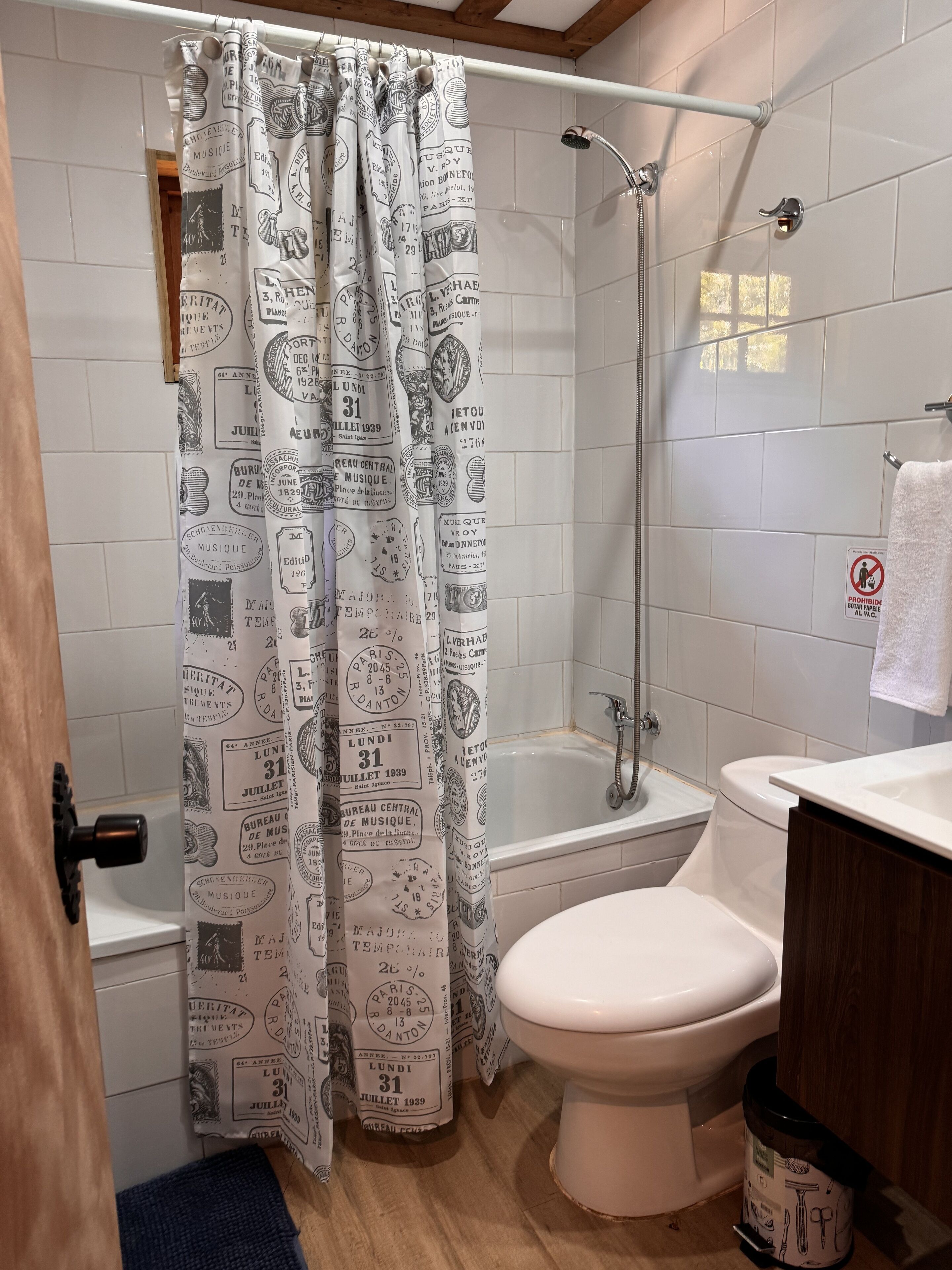 A bathroom with a shower, toilet, and sink.