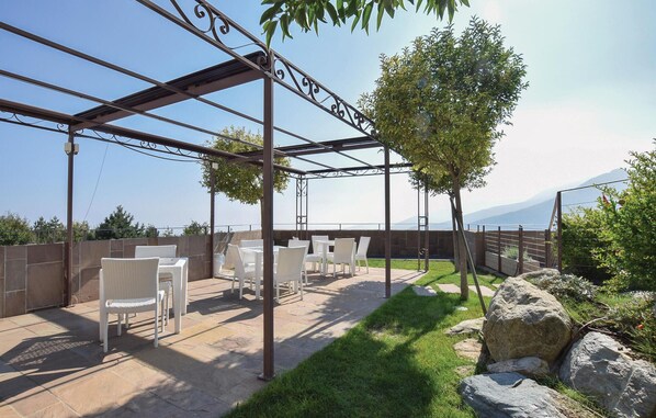 An outdoor patio with white wicker furniture, a pergola, and a view of the mountains. - Gorgeous home in Magliolo with house sea view (Magliolo)