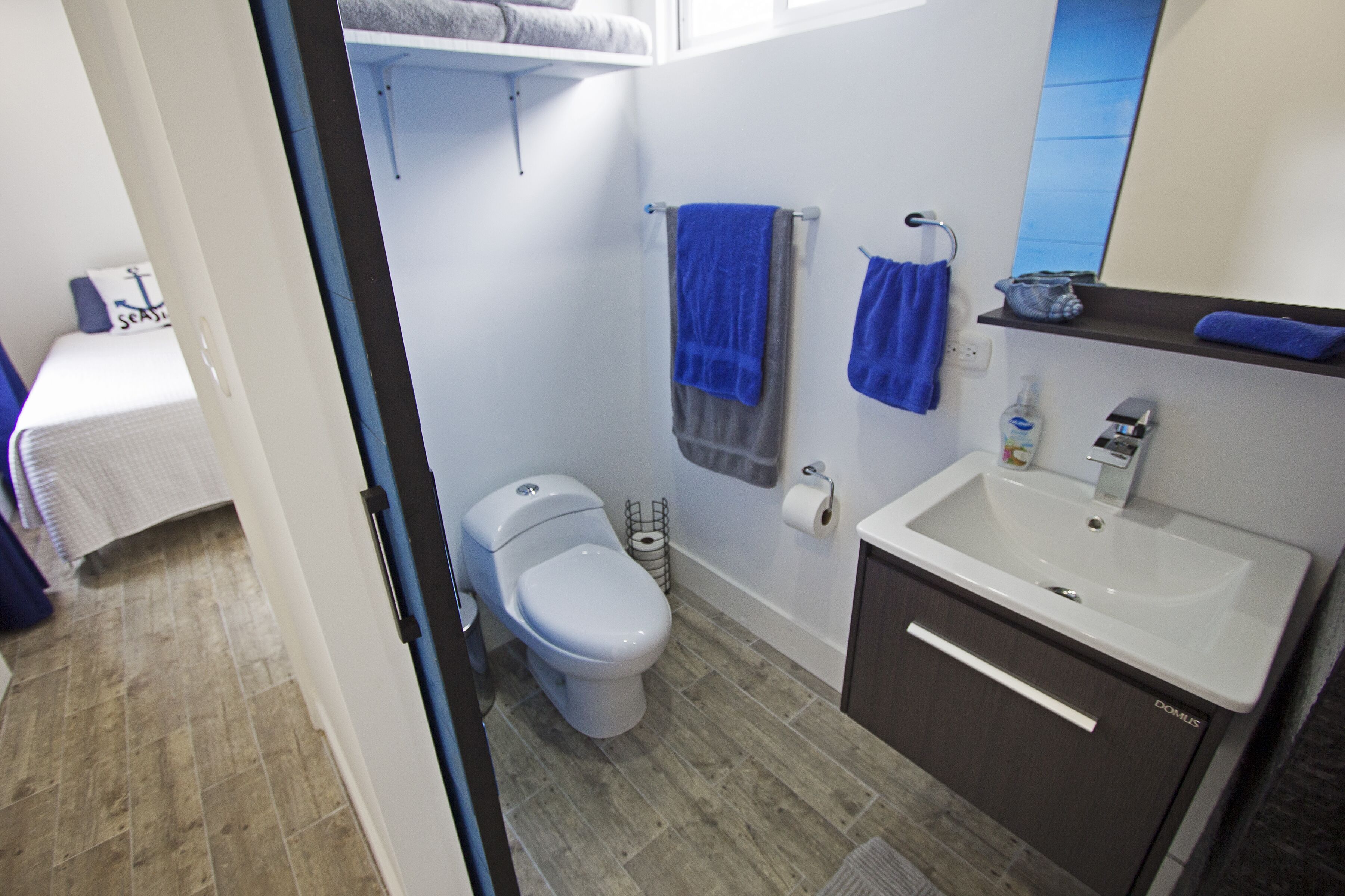 Une salle de bain équipée de toilettes, d’un lavabo et d’un porte-serviettes.