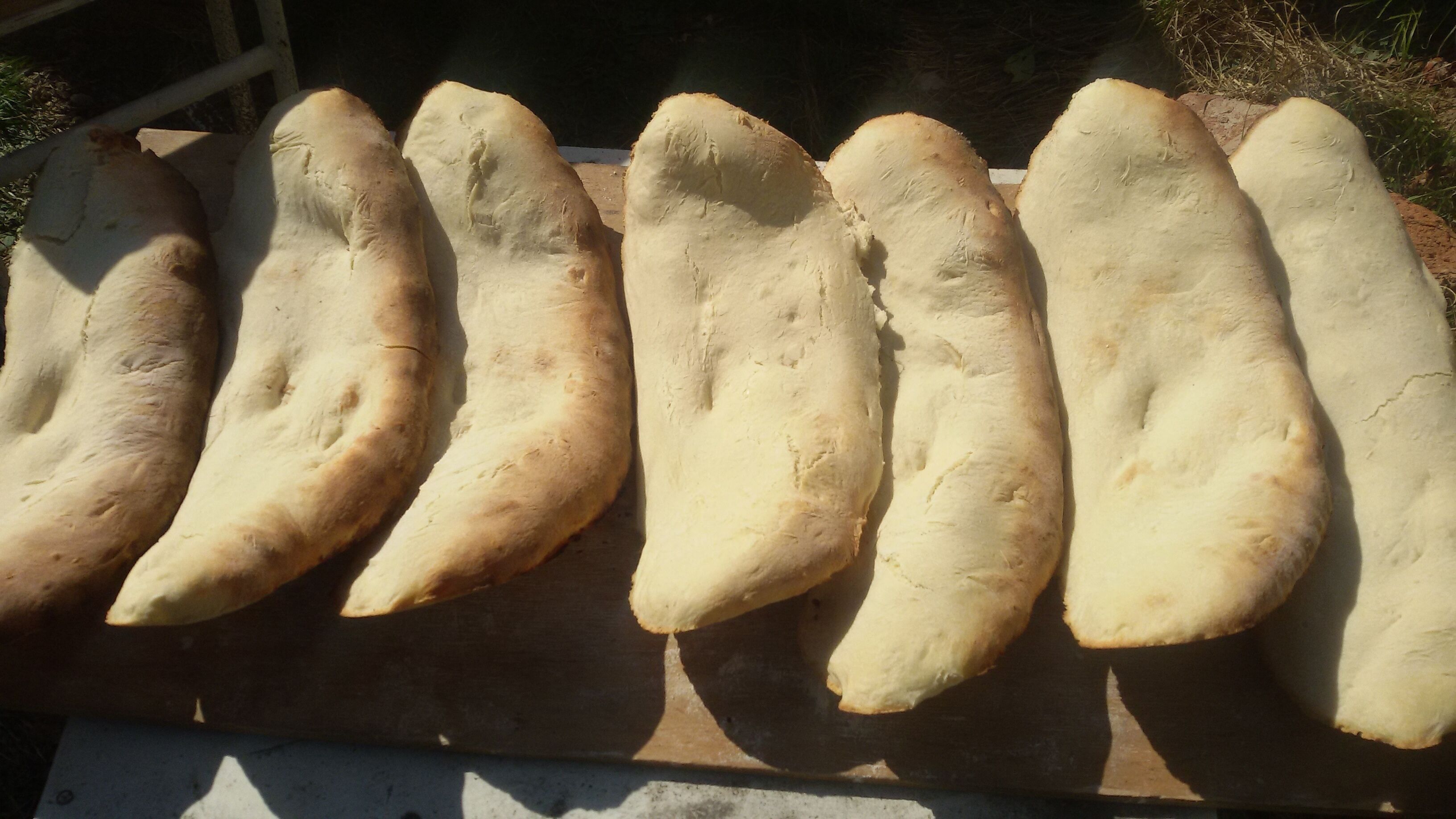 Several loaves of bread on a wooden board.