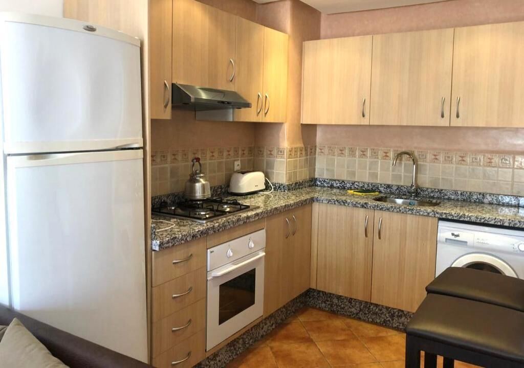 A compact kitchen with a refrigerator, stove, oven, and dishwasher.