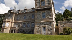 Un grand bâtiment en pierre doté de nombreuses fenêtres et d’une entrée centrale.