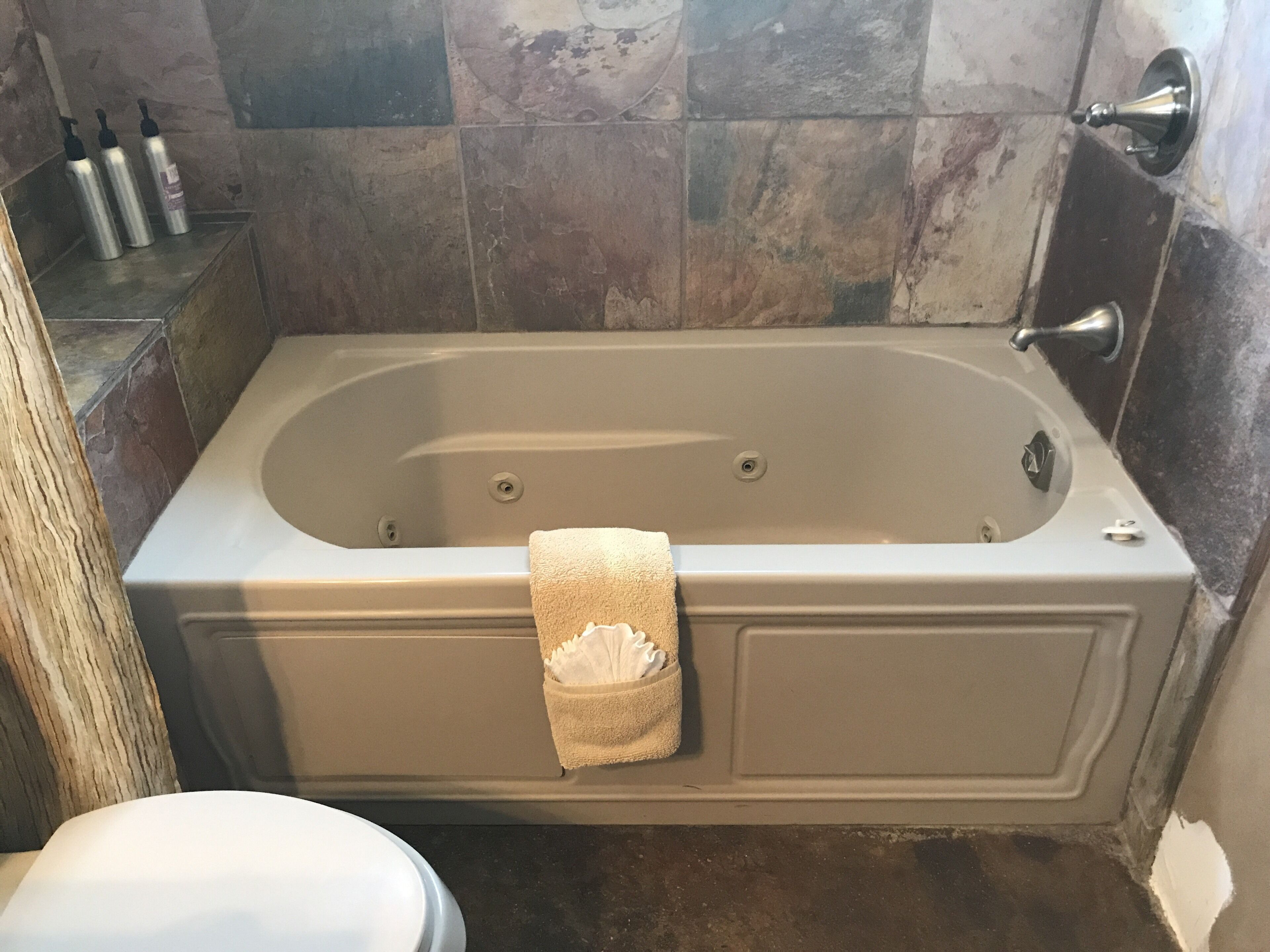 Een badkamer met een bad, een toilet en een handdoekhouder.