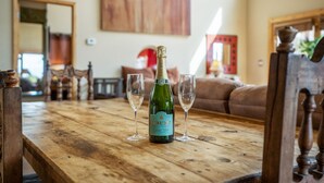 Una taula de fusta amb una ampolla de brut champany i dues flautes.