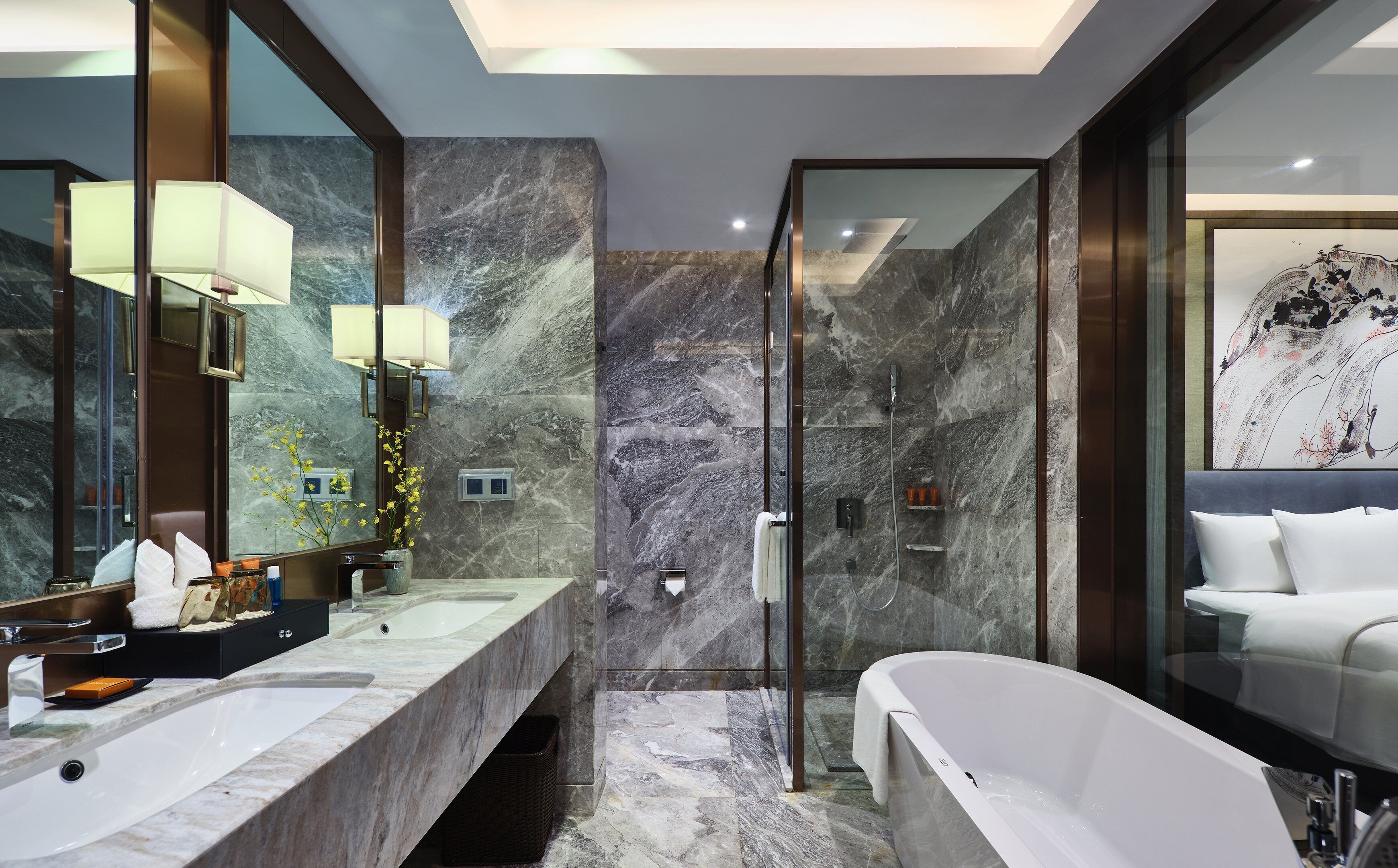 Un baño moderno con lavamanos de mármol, ducha con cerramiento de vidrio y bañera blanca.