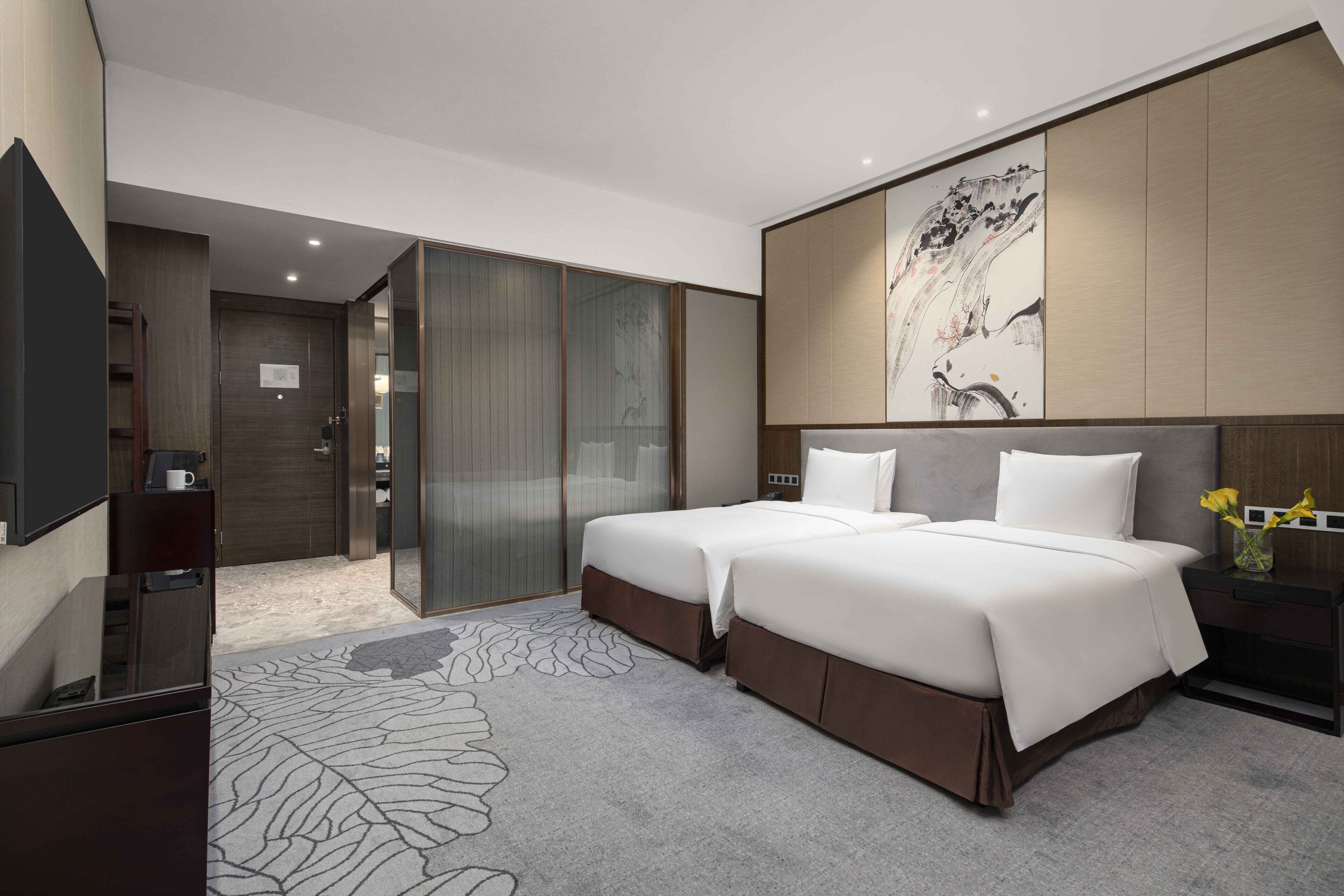 Una habitación de hotel moderna con una cama grande, un escritorio, un televisor de pantalla plana y un armario con puerta corredera.