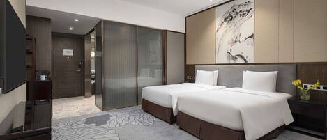 Una habitación de hotel moderna con una cama grande, un escritorio, un televisor de pantalla plana y un armario con puerta corredera.